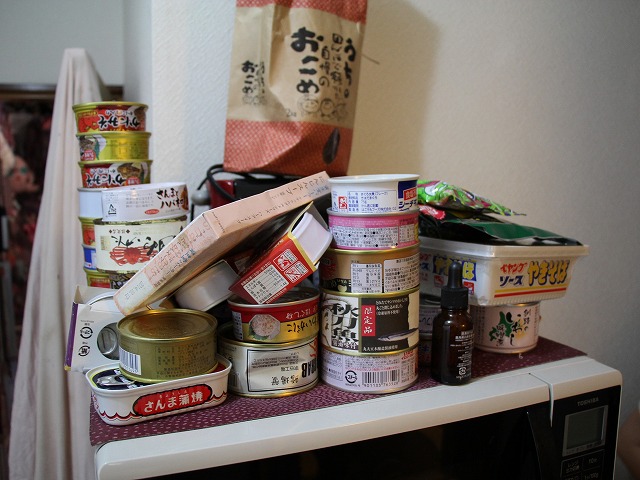 電子レンジの上にある缶詰の数々。よく見ると、かにみそやサンマなど、結構いいものだが……?